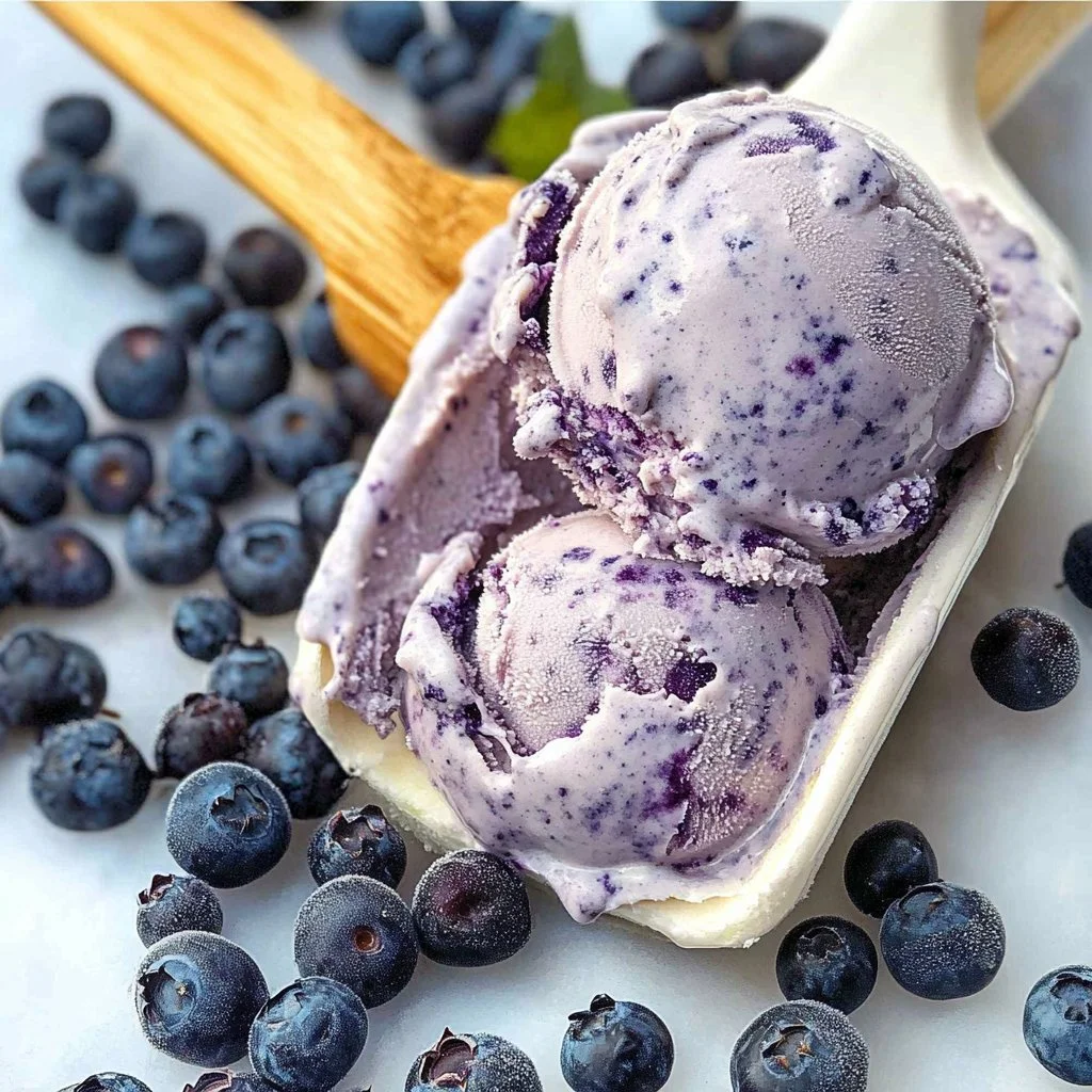 No-churn blueberry ice cream in a bowl, topped with fresh blueberries