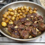 Garlic Herb Ribeye Steak served with crispy potatoes on a plate