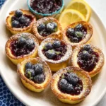 Mini Dutch Baby Pancakes garnished with blueberry lemon compote on a plate