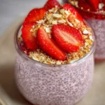 Strawberry crumble chia pudding served in a glass bowl with fresh strawberries