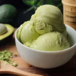 Homemade avocado ice cream in a bowl with fresh avocado slices on top
