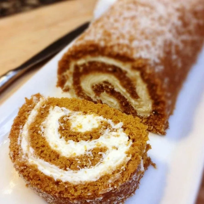 Classic pumpkin roll dessert with cream filling on a plate