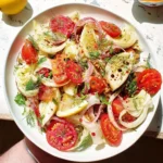Fennel with roasted lemon and tomato salad garnished with herbs