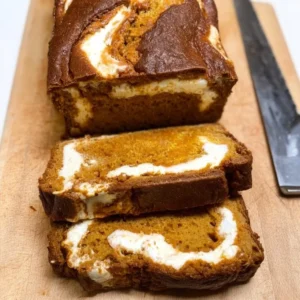 Loaf of homemade pumpkin cream cheese bread with seasonal spices