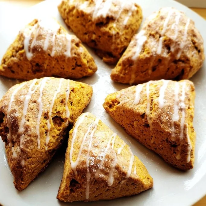 Freshly baked pumpkin scones with spices and glaze on a plate