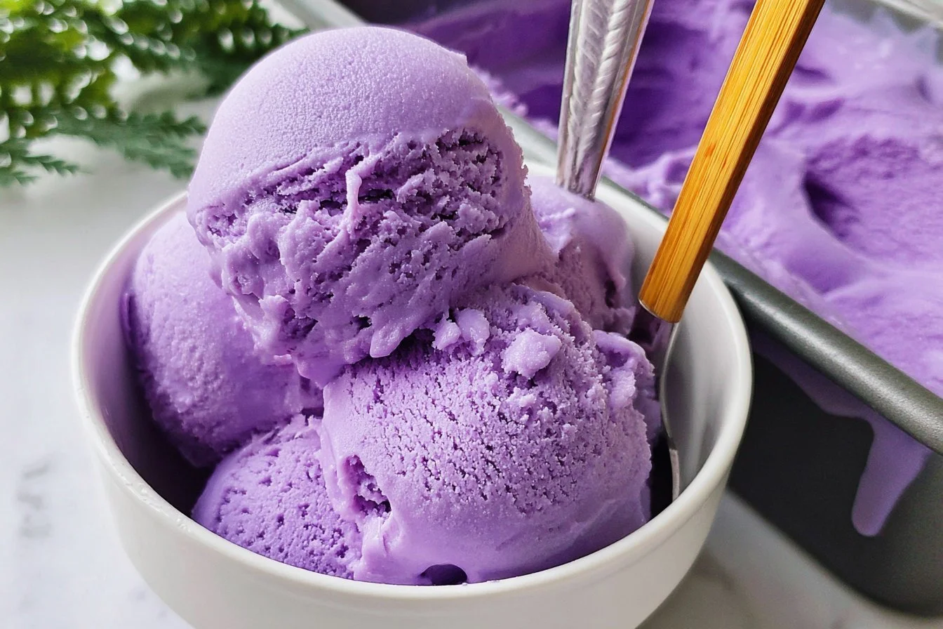 A bowl of vibrant purple ube ice cream topped with coconut flakes.