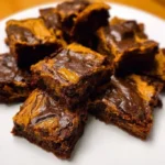 Delicious vegan pumpkin brownies served on a plate with chocolate drizzle