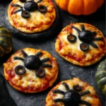 Plate of mini spider pizzas decorated for Halloween