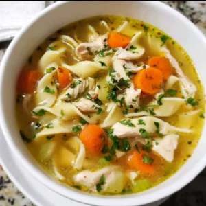 Bowl of homemade chicken noodle soup with vegetables and herbs