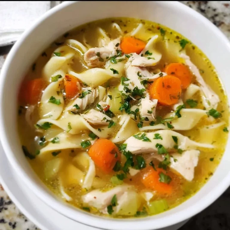 Bowl of homemade chicken noodle soup with vegetables and herbs