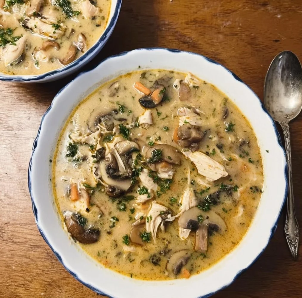 Bowl of creamy rotisserie chicken mushroom soup topped with herbs