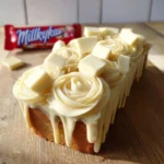 Delicious Milkybar Loaf Cake topped with creamy frosting
