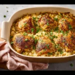 Oven baked chicken and rice served on a plate with fresh herbs as garnish