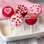 Valentine's Day Oreo Pops decorated with pink and red chocolate and sprinkles
