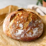 Freshly baked 2-ingredient no-knead artisan bread on a wooden table