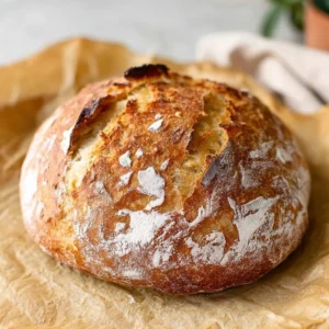 Freshly baked 2-ingredient no-knead artisan bread on a wooden table