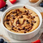 Baked protein pancake bowl topped with fresh fruits and nuts