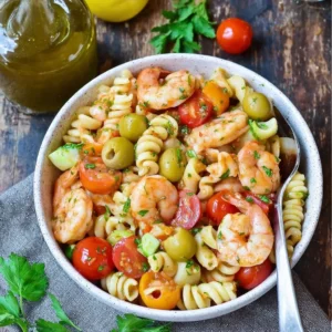A vibrant Bloody Mary Shrimp Pasta Salad with shrimp, pasta, and fresh vegetables