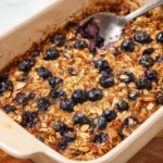 Delicious blueberry baked oatmeal served in a bowl with fresh blueberries on top.