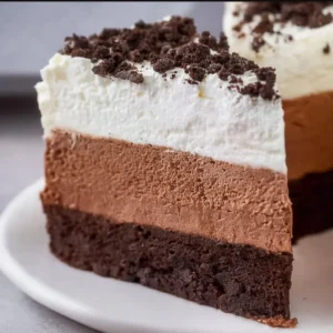 Decadent Oreo Mousse Cake topped with crushed Oreos and whipped cream