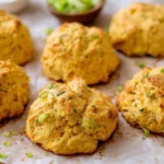 Homemade plant-based corn biscuits on a rustic wooden table.