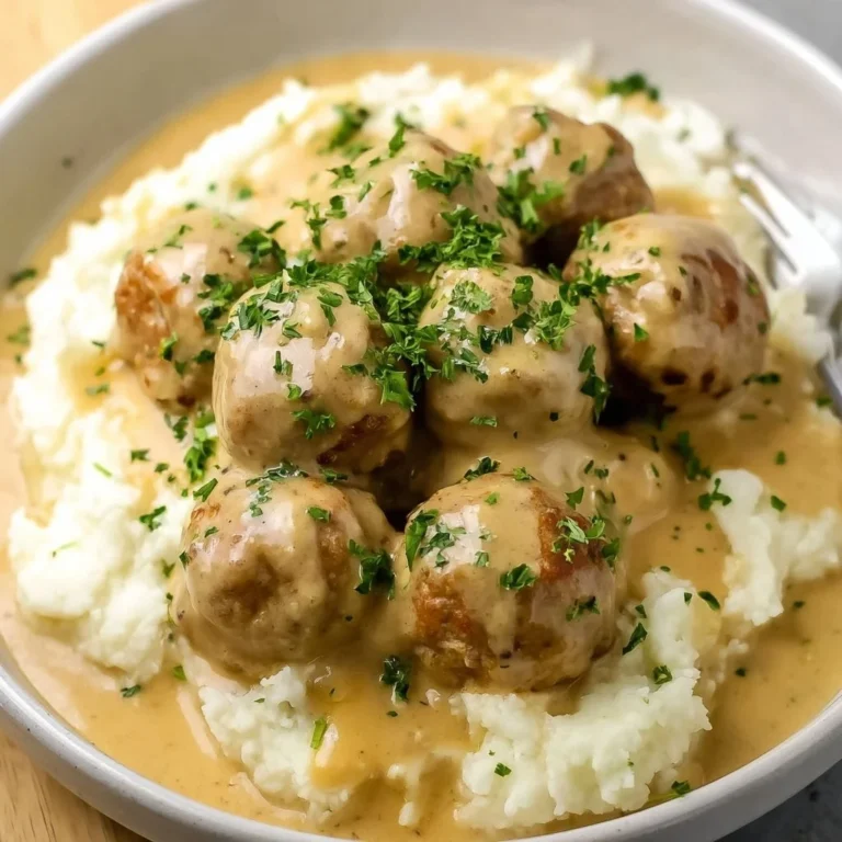 Plate of Vegan Swedish Meatballs served with gravy and garnished with parsley.
