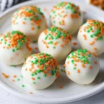 Delicious carrot cake truffles coated in creamy frosting and sprinkled with nuts.