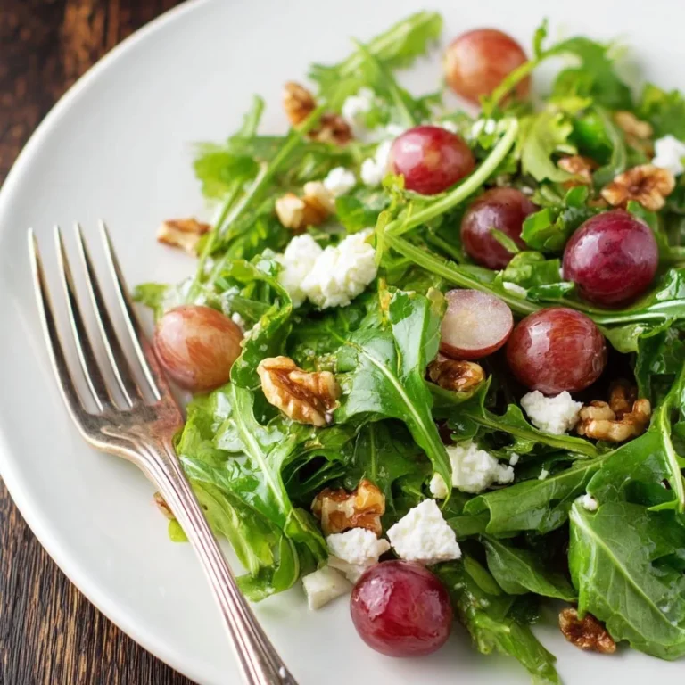 Grape salad with candied walnuts in a bowl, topped with fresh mint leaves.